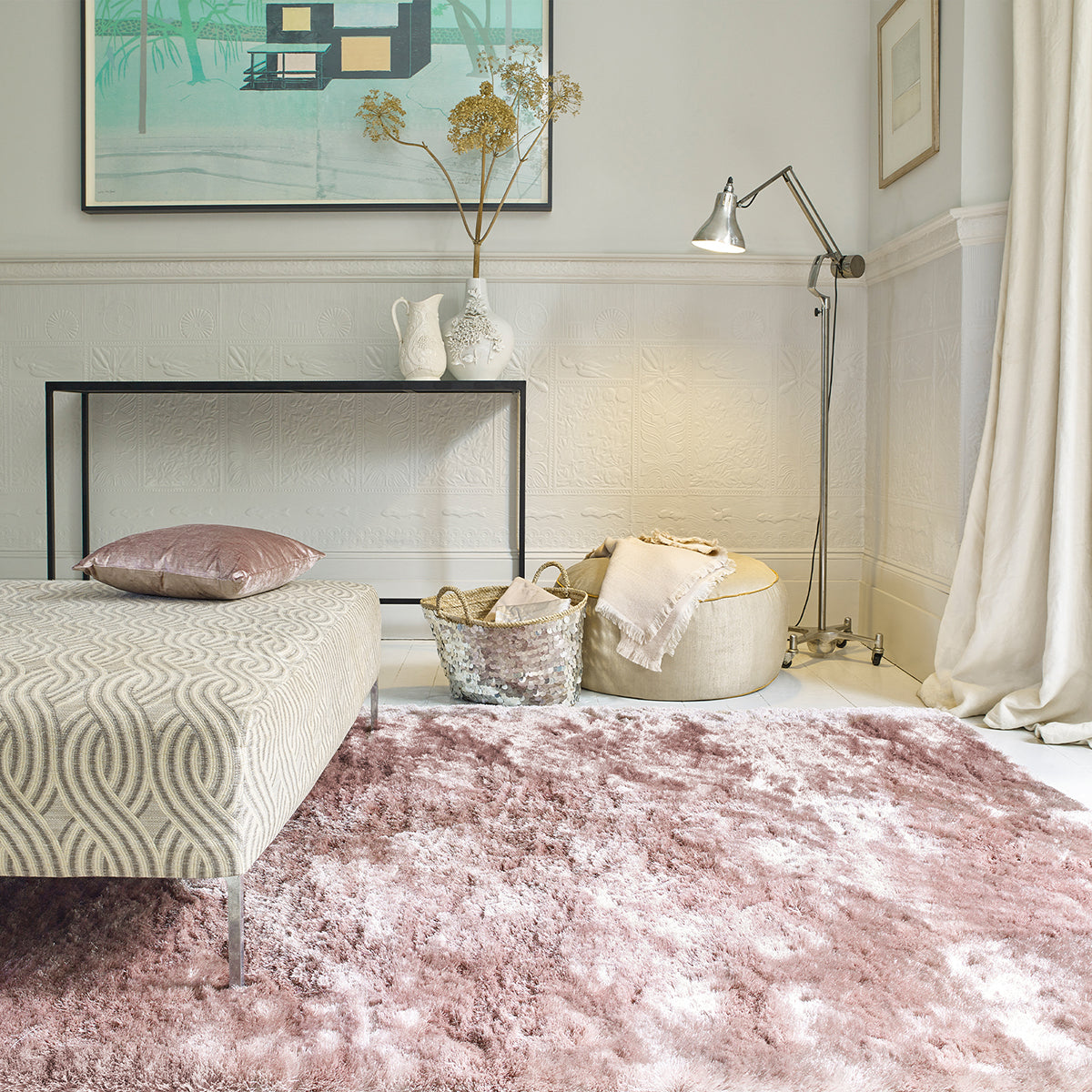 Neatly arranged bedroom with pink rug, bed, and decor elements.