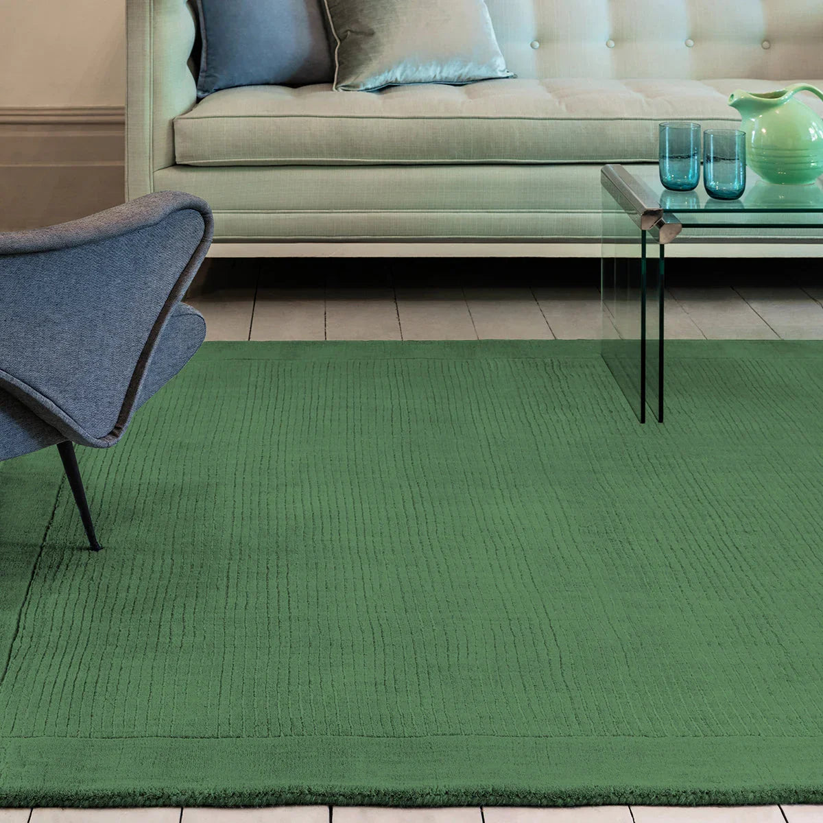 Green rug in a living room with a sofa, chair, and coffee table.