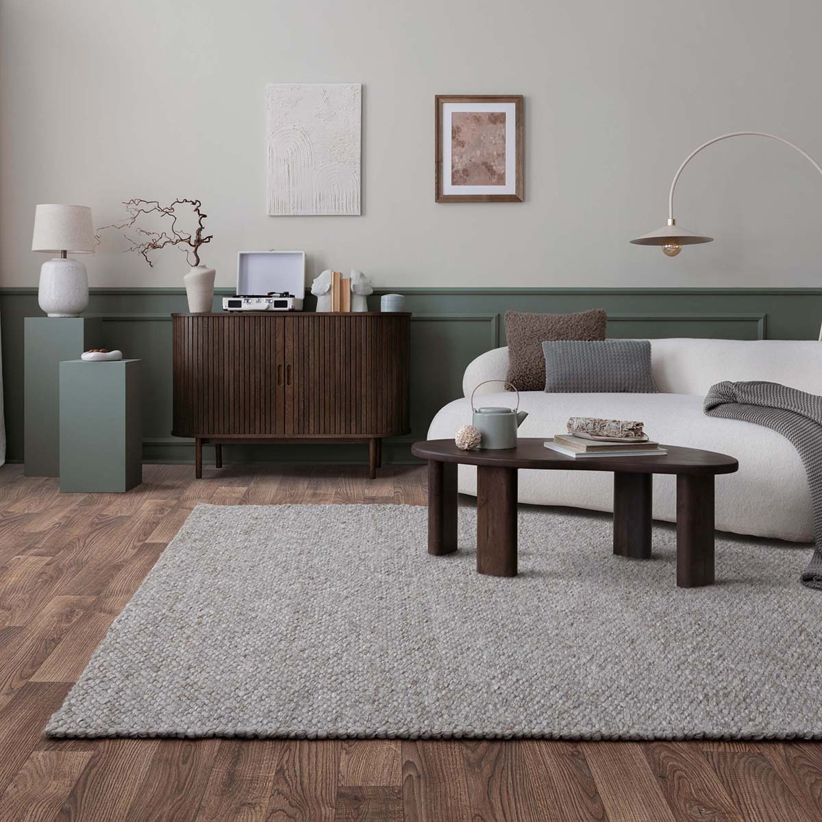Modern living room with a gray rug, wooden coffee table, and white sofa.