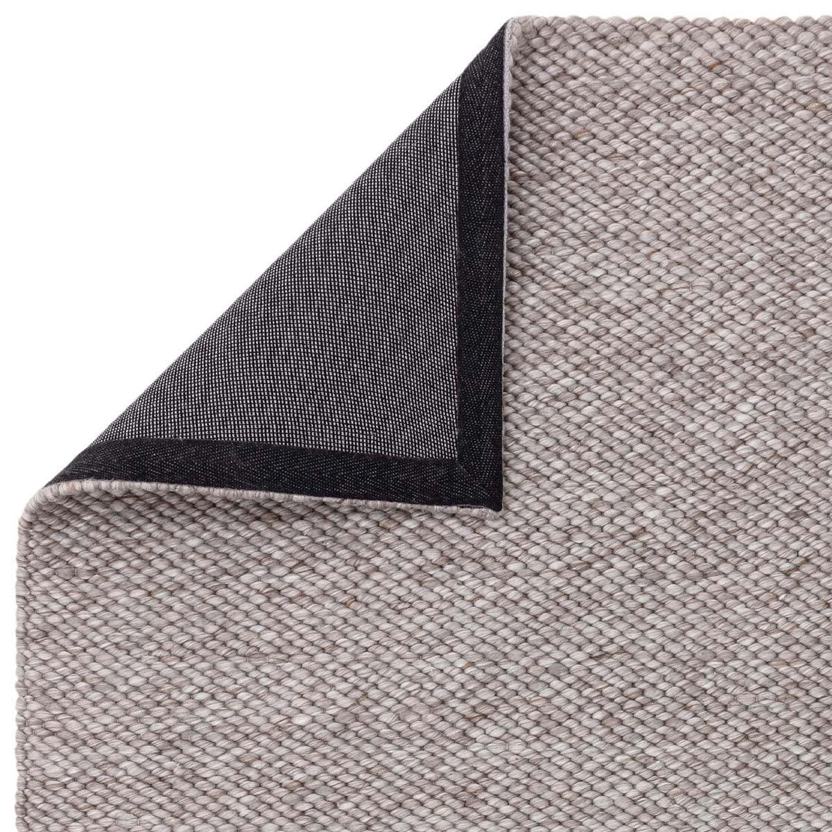 Asiatic Zander Charcoal Designer Rug featuring textured weave in charcoal grey and black on light grey background, hand-tufted wool