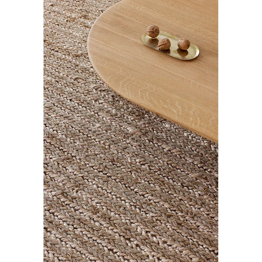 Brink & Campman Craft Plait Natural rug featuring braided plait texture in beige and taupe on a light floor, hand-woven jute