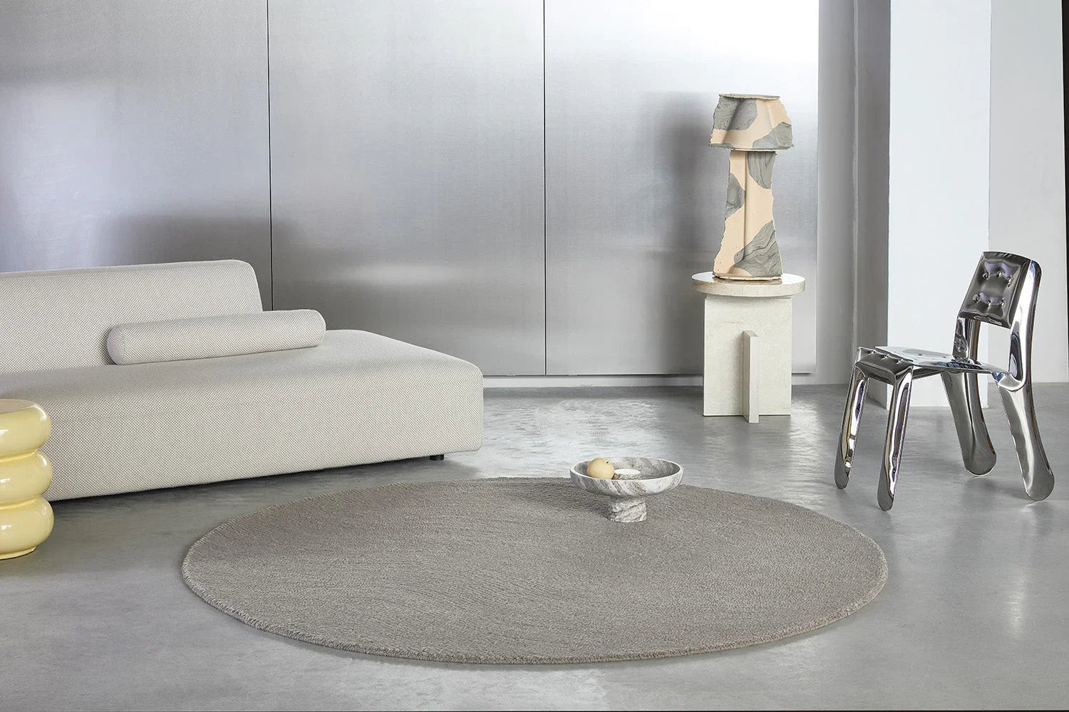 B&C Decor Echo Pebble Round Rug featuring minimalist textured pattern in taupe, beige and greige on light grey floor, machine-woven wool