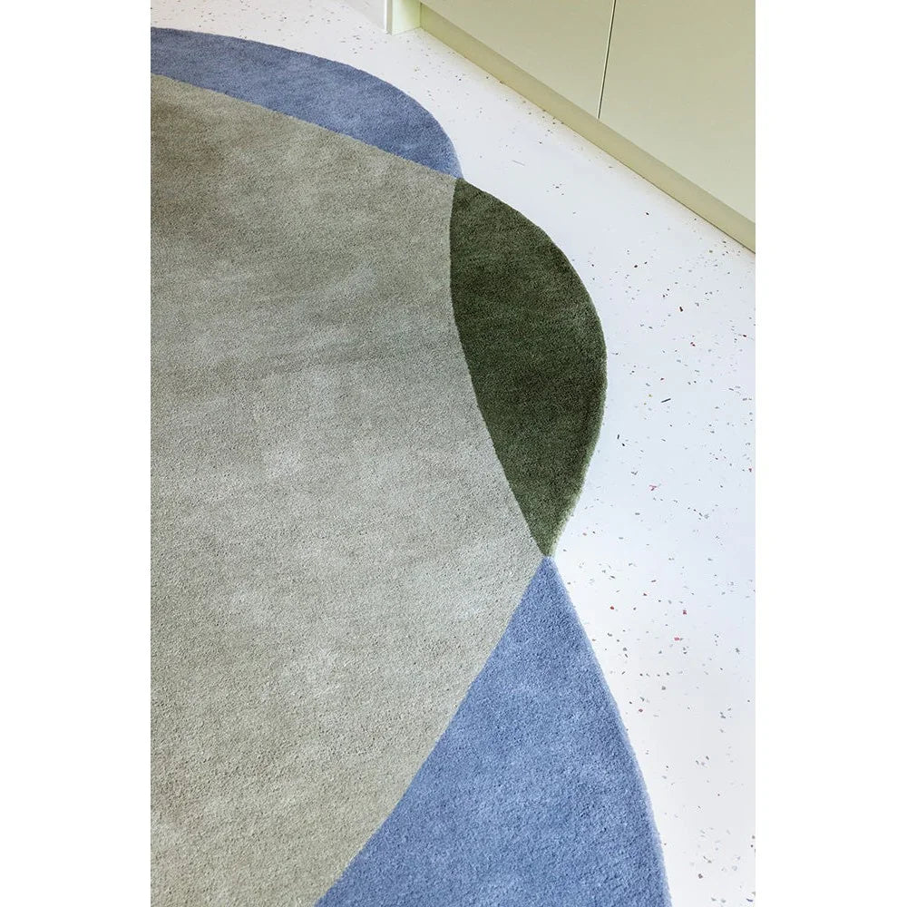 Brink & Campman Element Chad rug featuring abstract circle pattern in grey, sage-green, navy and blue on pale background, hand-tufted wool