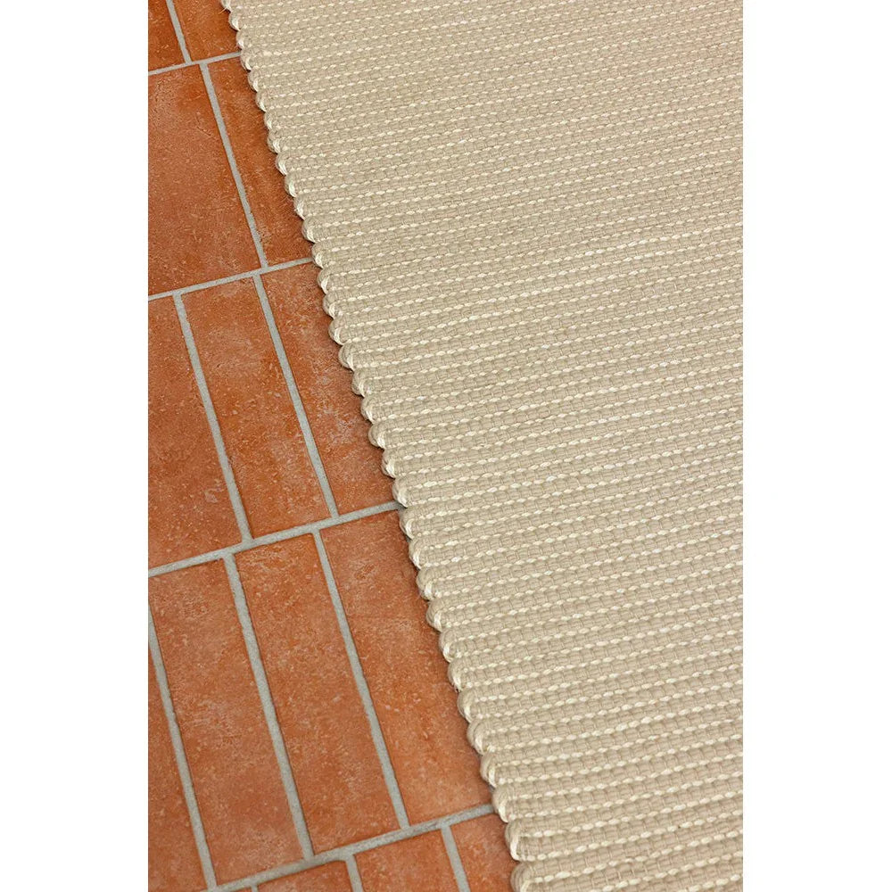 Brink & Campman Frame Natural Rug featuring striped woven texture in cream and beige on terracotta floor, hand-tufted wool