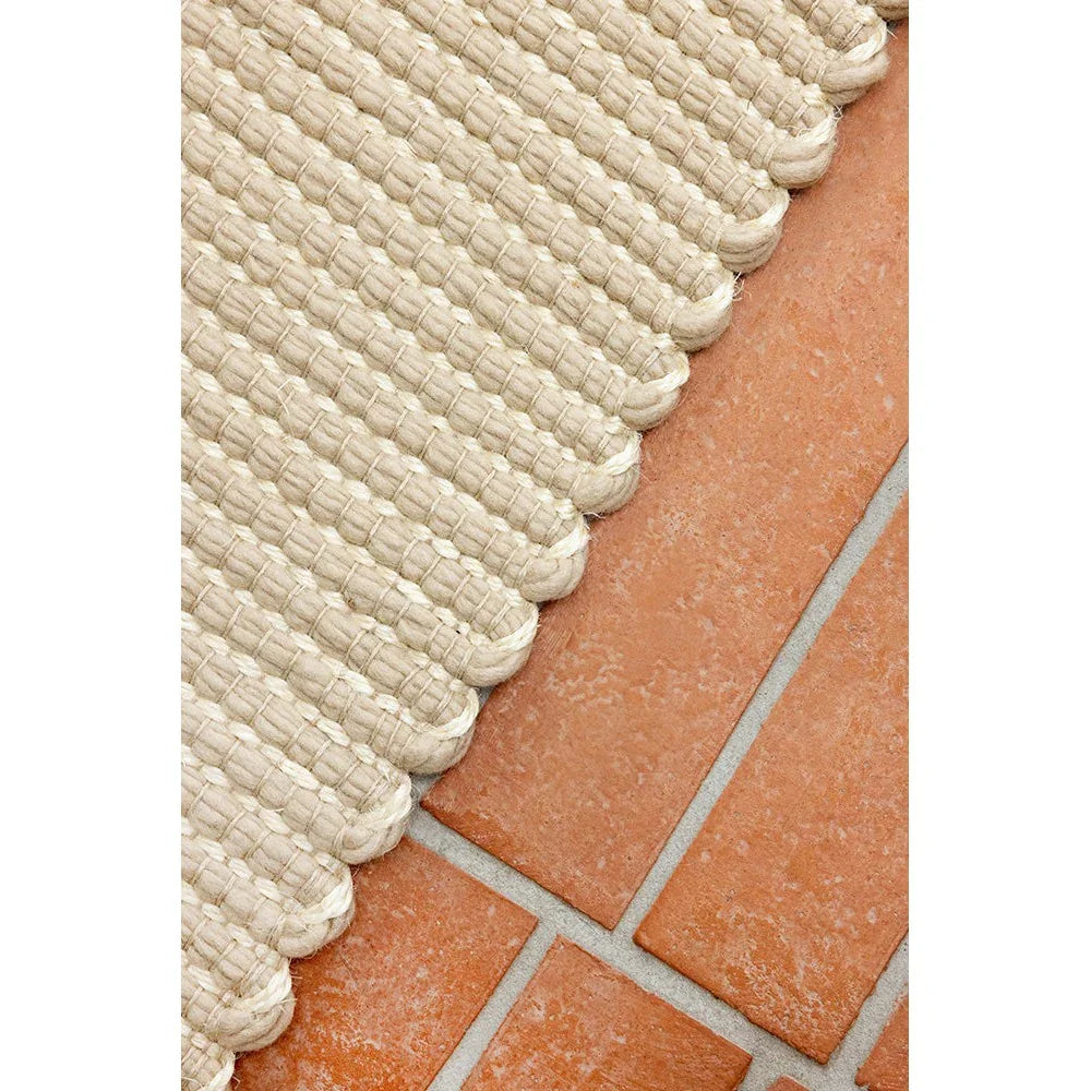 Brink & Campman Frame Natural rug featuring braided jute texture in beige on terracotta tiles, hand-braided construction