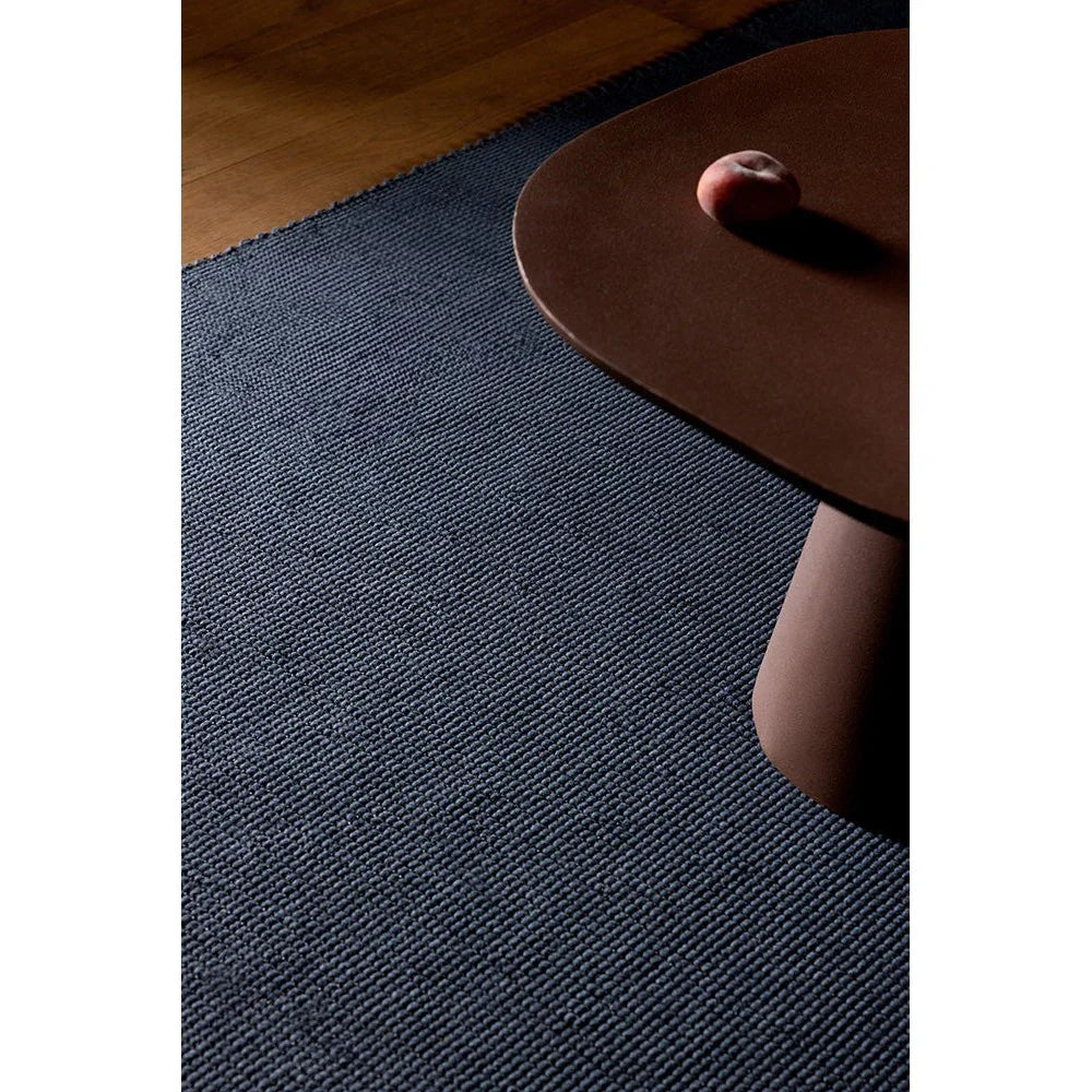 Brink & Campman Grid Slate Designer Rug featuring geometric grid pattern in slate blue, charcoal on warm wooden floor, hand-tufted wool