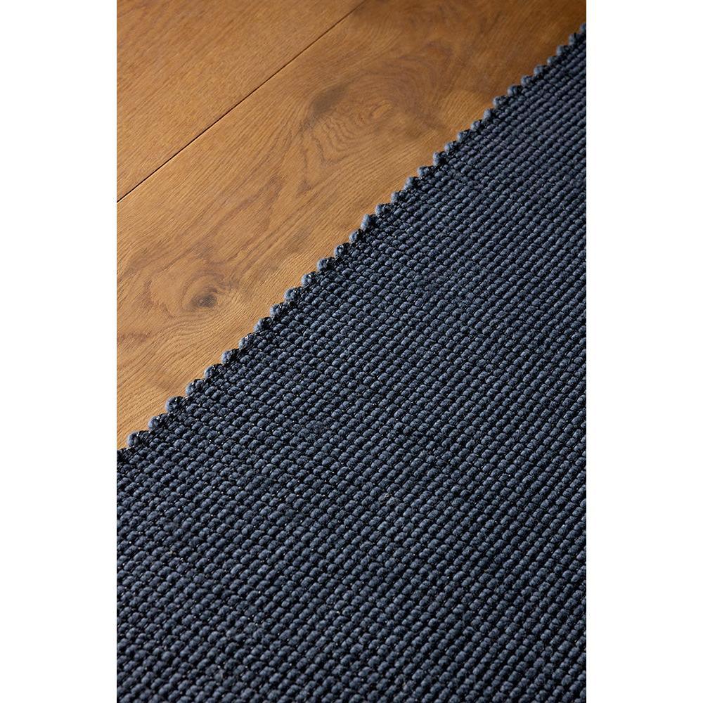Brink & Campman Grid Slate Designer Rug featuring a tight navy slate grid on warm oak floor, woven wool