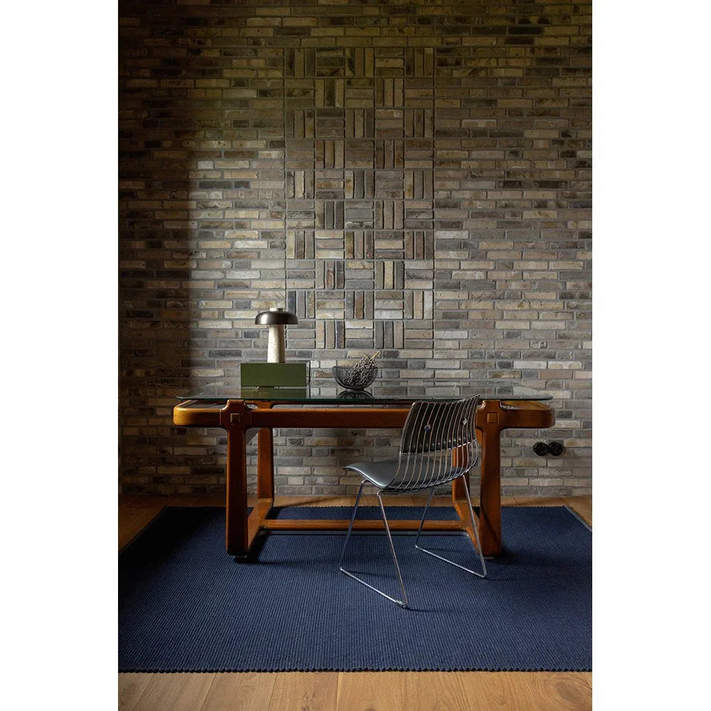 Brink & Campman Grid Ink designer rug featuring subtle grid texture in navy blue and charcoal on light wood floor