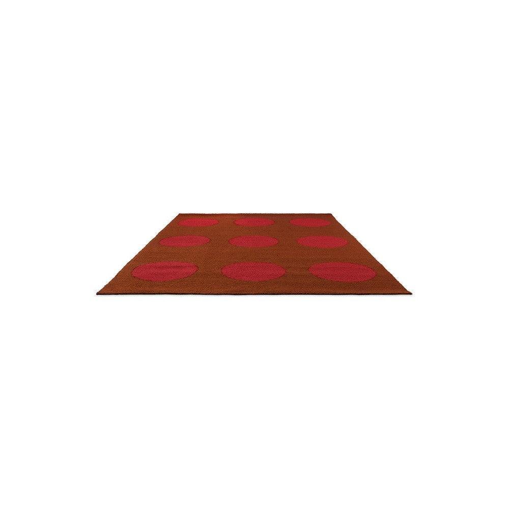 Brink & Campman Habitat Festival Dots outdoor designer rug featuring pink-red polka dots on burnt orange background