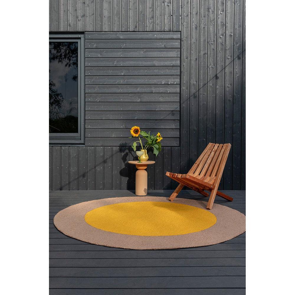 Brink & Campman Habitat Festival Round Yellow Outdoor Rug featuring concentric yellow and beige circle on grey deck, machine-made polypropylene
