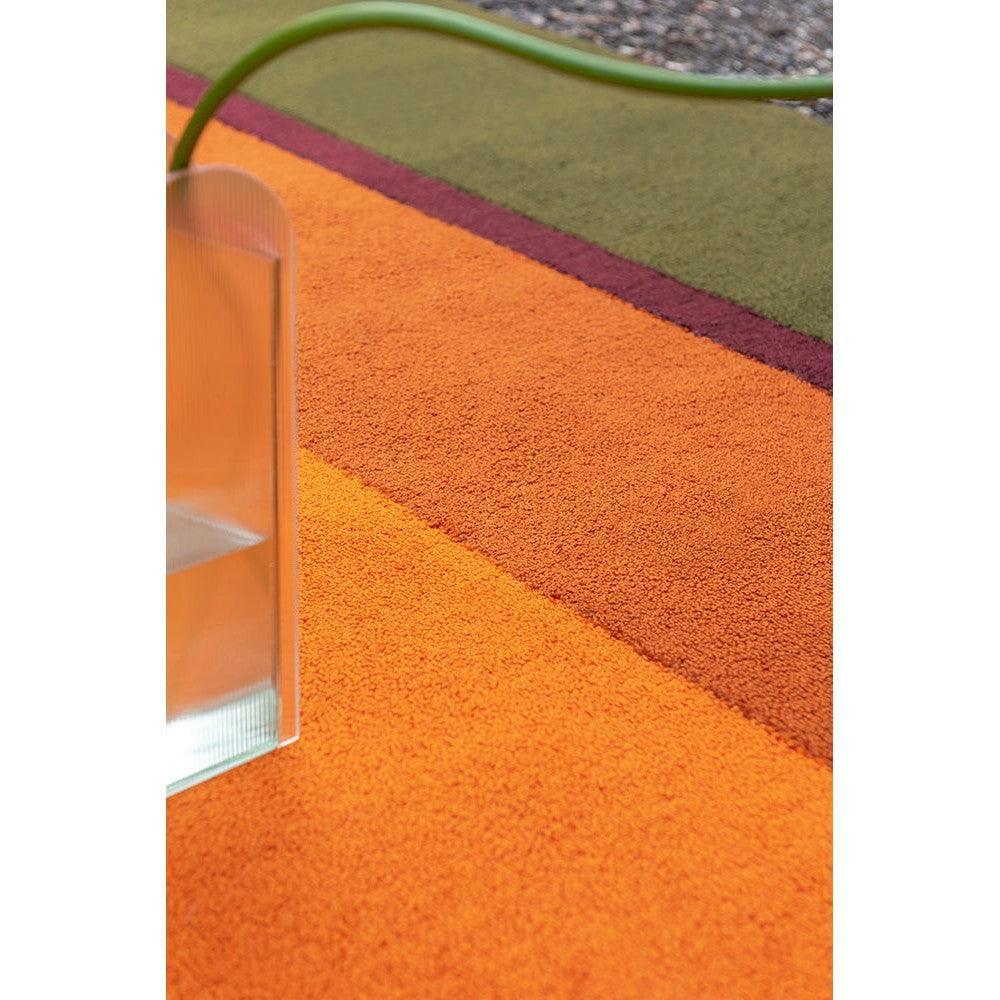 Brink & Campman Habitat Festival Stripe orange outdoor rug featuring bold orange & amber stripes with purple on green edge, machine-woven polypropylene