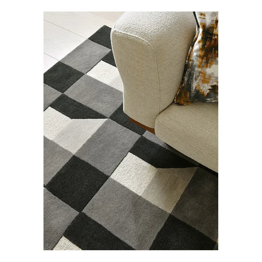 Harlequin Blocks Slate Rug featuring geometric patchwork in charcoal, slate, light grey and cream on light floor, hand-tufted wool