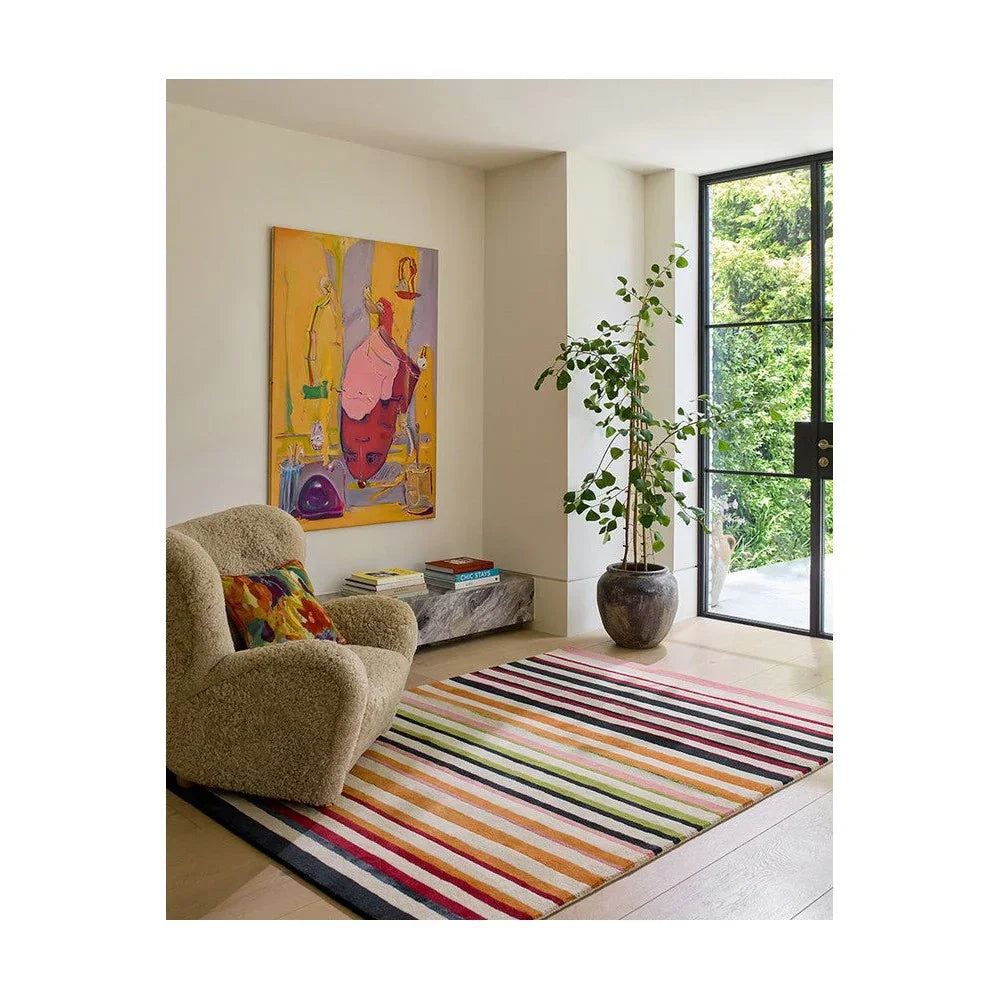 Harlequin Calla Pomegranate / Clementine Designer Rug featuring striped pattern in pink, orange, yellow, lime, navy on cream background, hand-tufted wool