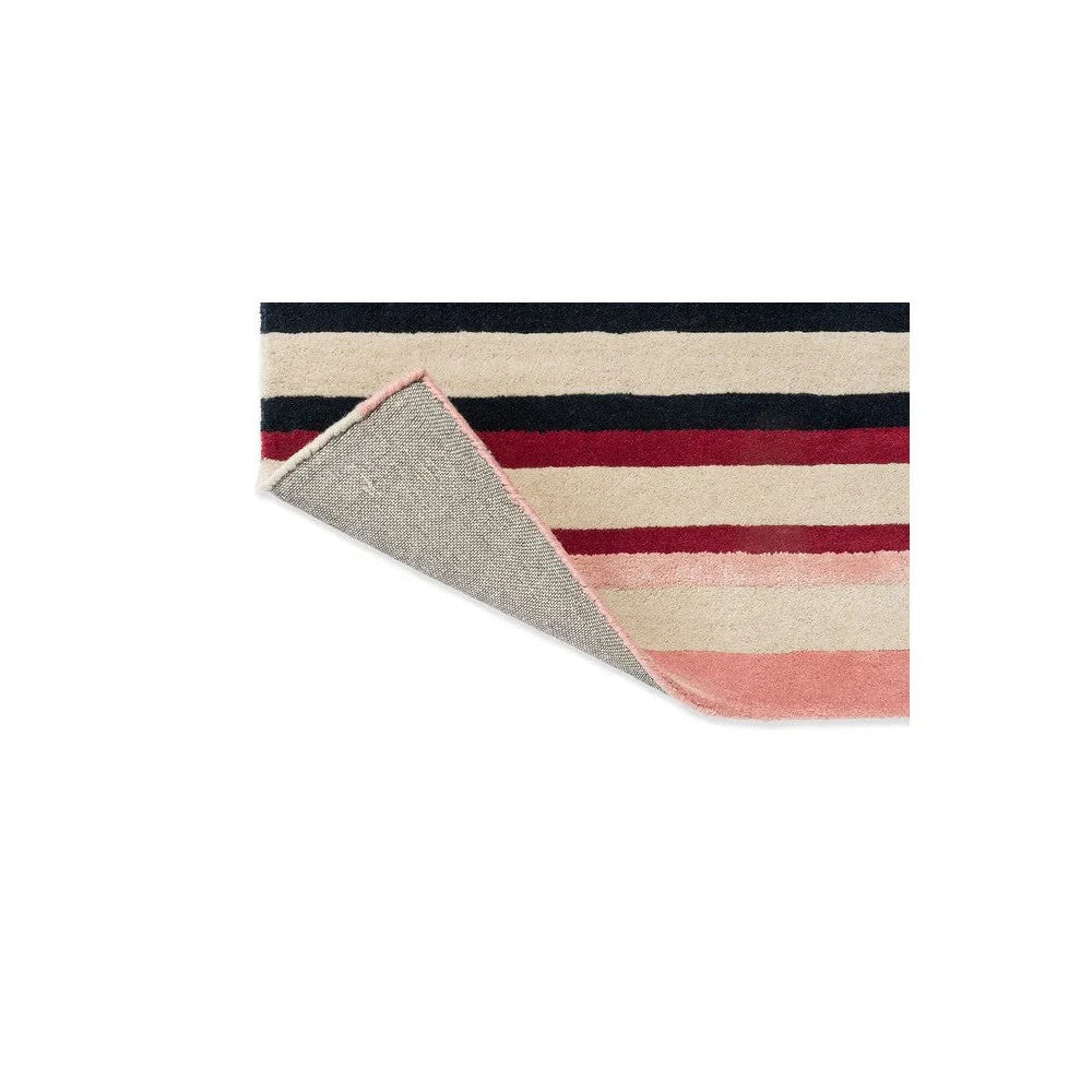 Harlequin Calla rug featuring horizontal stripe pattern in navy, cream, pomegranate and peach on beige background, machine-woven wool