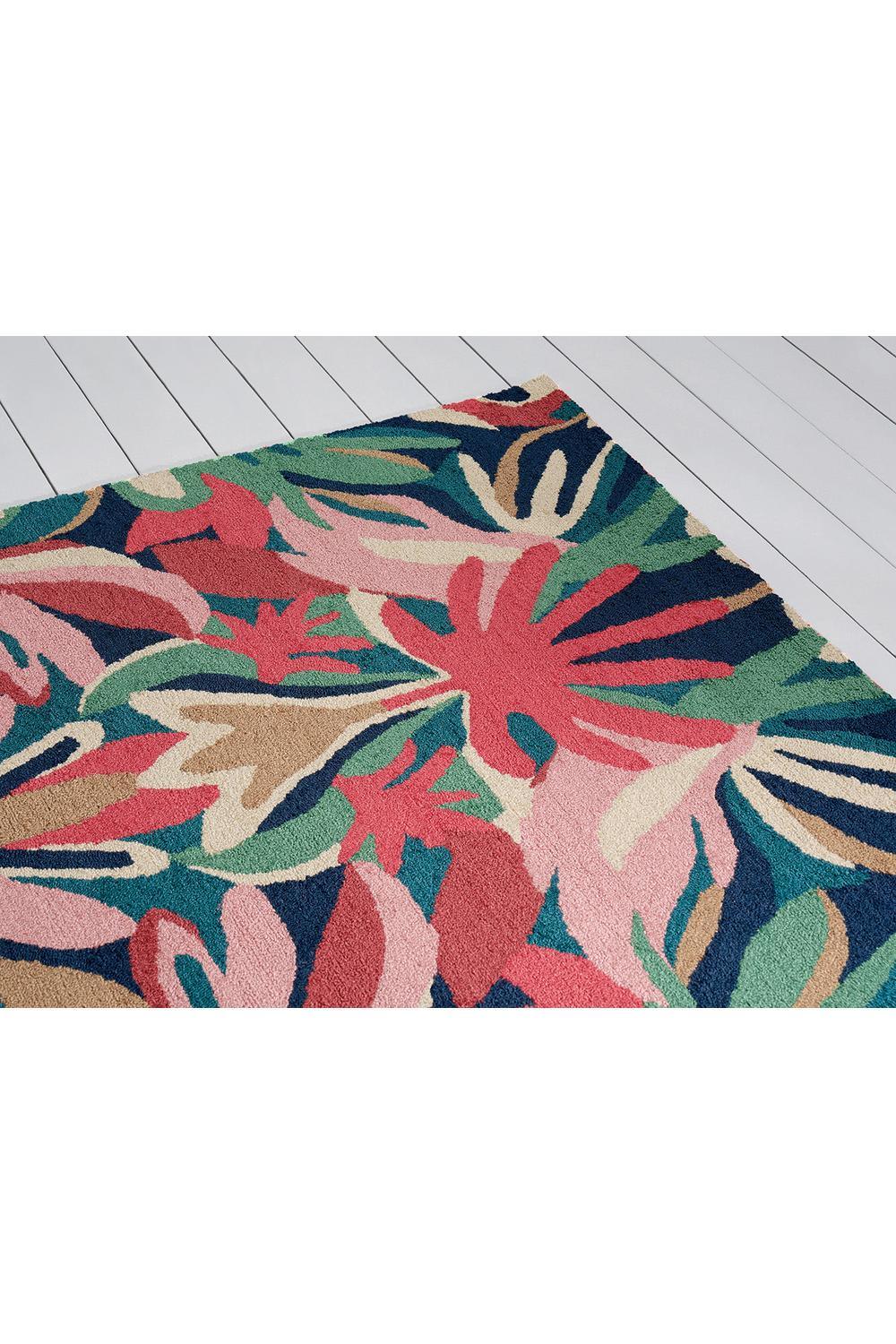 Harlequin Melora Pink Designer Outdoor Rug featuring tropical floral pattern in pink, coral, teal, emerald and navy on deep navy background, power-loomed polypropylene