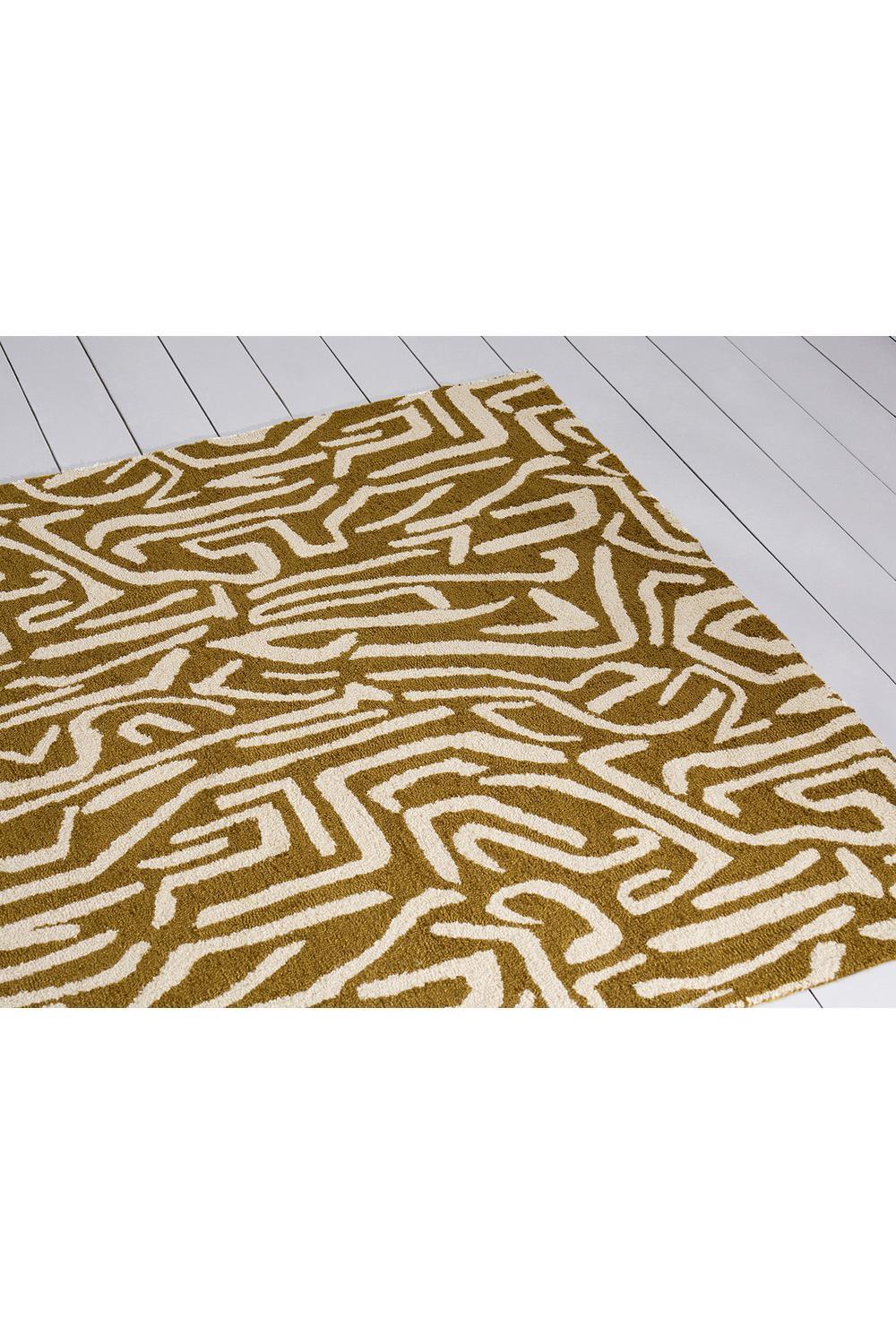 Harlequin Melodic Ochre outdoor rug featuring abstract geometric pattern in ochre and white on white background, machine-made polypropylene