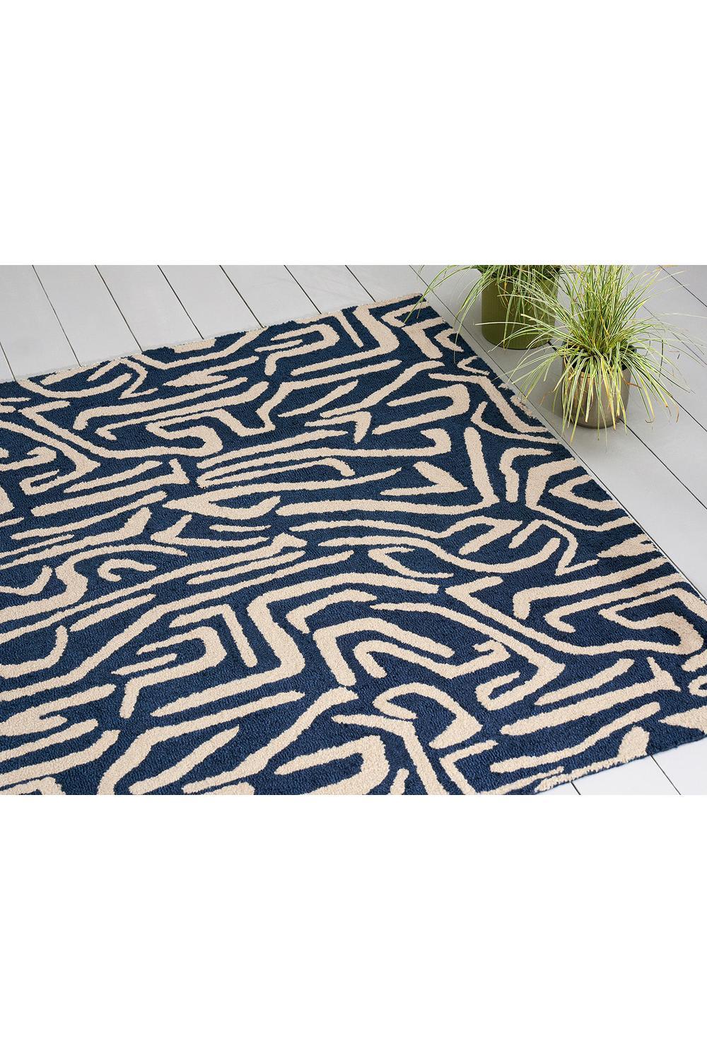 Harlequin Melodic Blue Outdoor Rug featuring abstract maze pattern in navy blue and cream on beige background, power-loomed polypropylene
