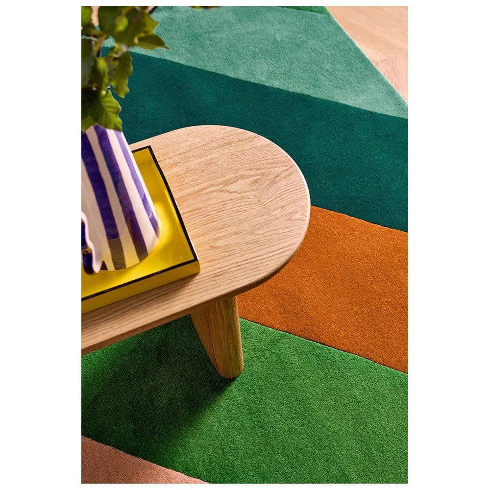 Sophie Robinson x Harlequin Sherbet Stripe Emerald/Amber Designer Rug featuring color-block stripes in emerald, teal and orange on green background, machine-woven synthetic
