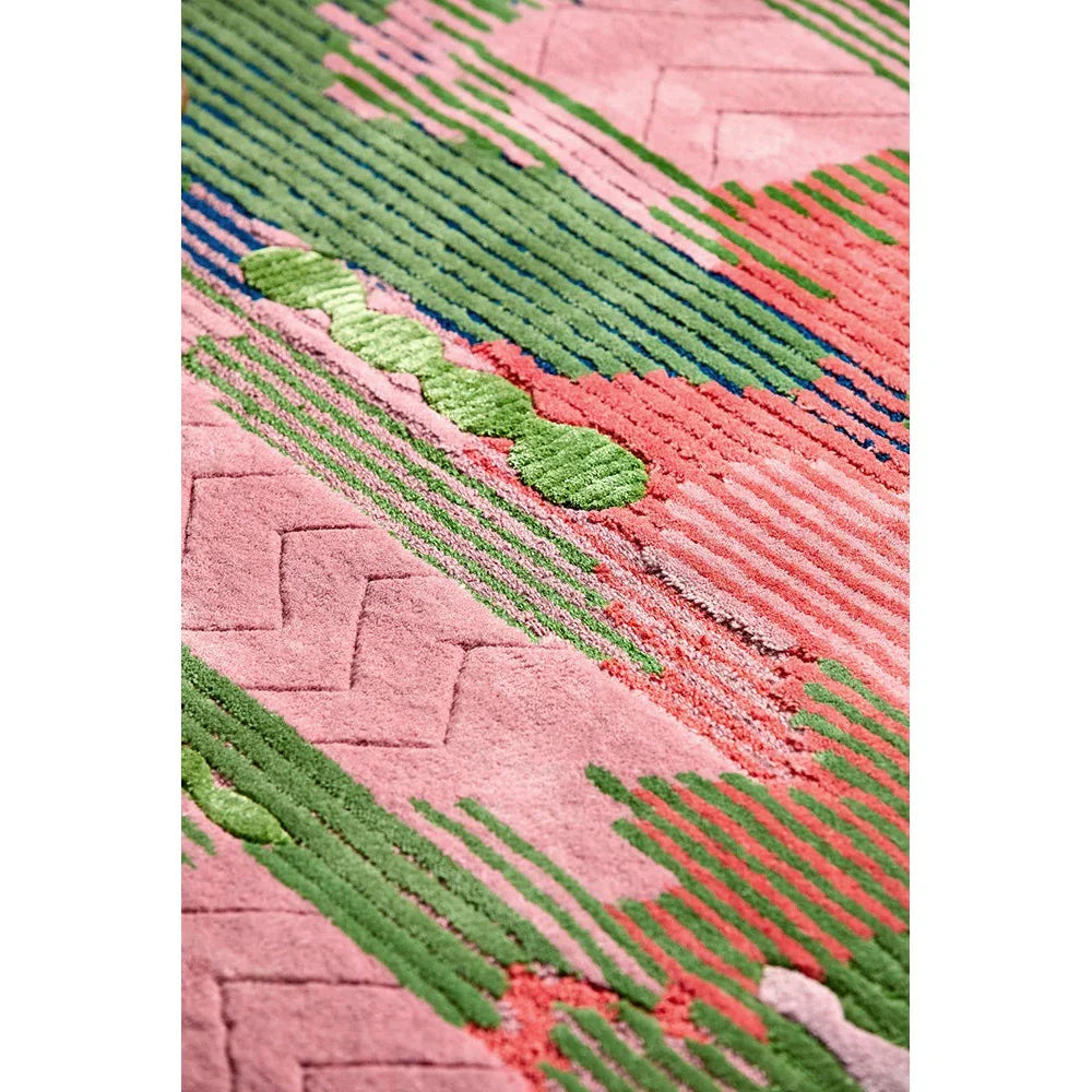 Sophie Robinson x Harlequin Wilderness rug featuring abstract stripe pattern in pink, emerald green and peridot on pink background, hand-tufted wool