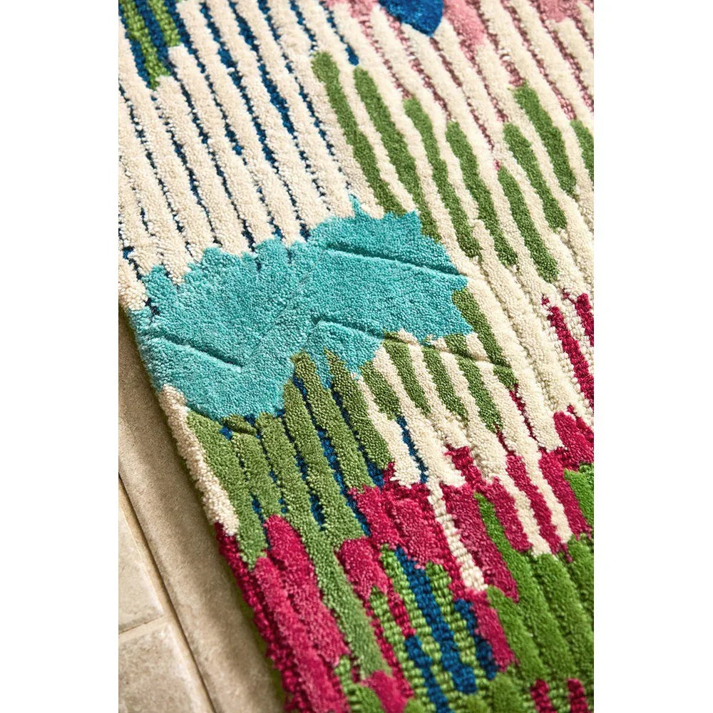 Sophie Robinson x Harlequin Wilderness rug featuring striped floral pattern in peridot green, emerald, turquoise, magenta on cream background, hand-tufted wool