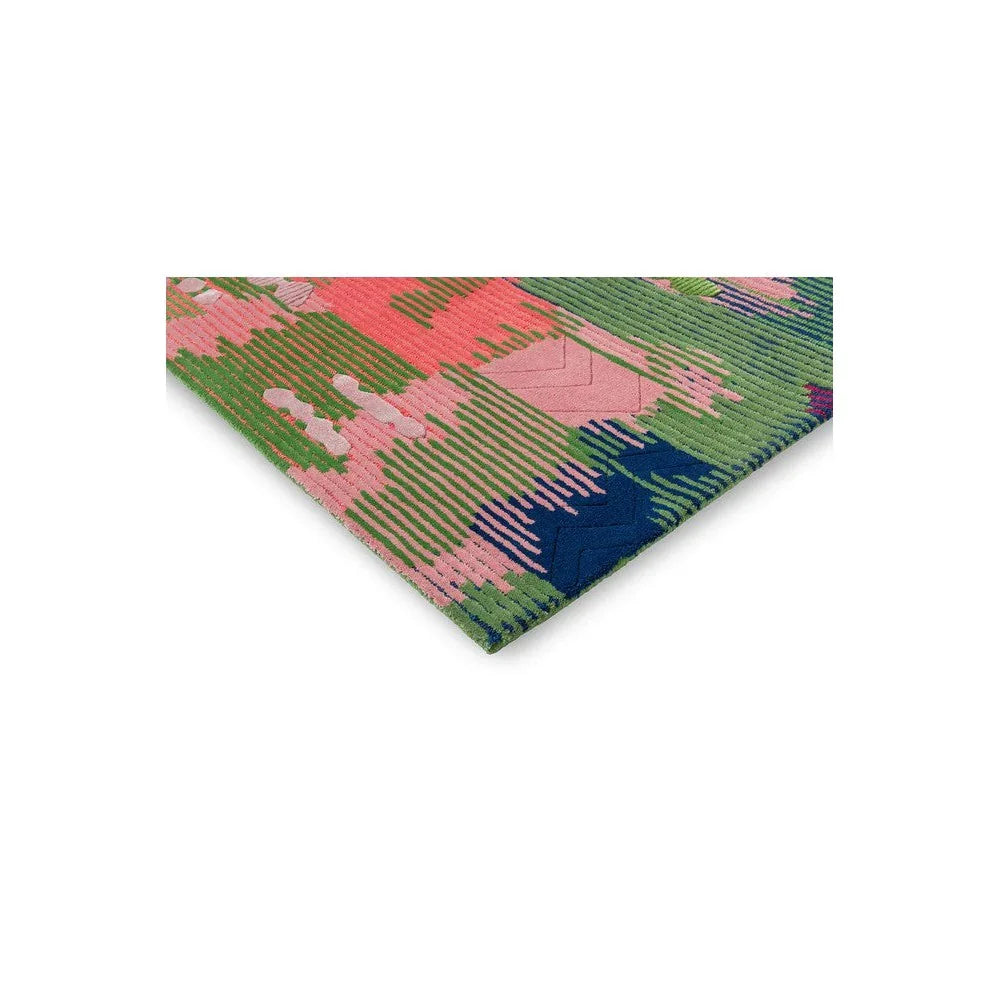 Sophie Robinson x Harlequin Wilderness rug featuring bold geometric pattern in peridot, emerald, pink and green on pink background, hand-tufted wool