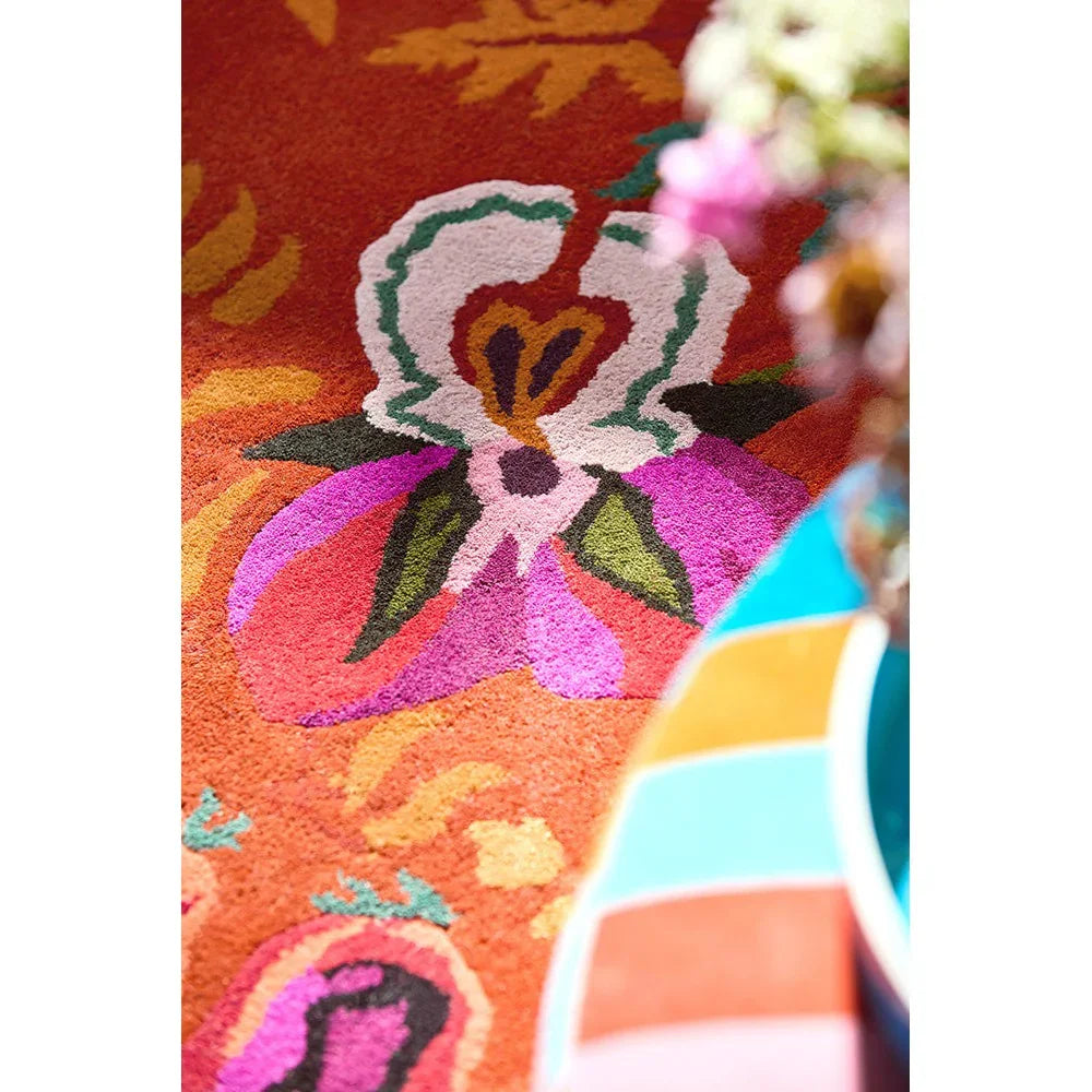 Sophie Robinson x Harlequin Wonderland Floral Amber/Lapis Designer Rug featuring floral pattern in amber, white, pink, purple and green on amber background, hand-tufted wool