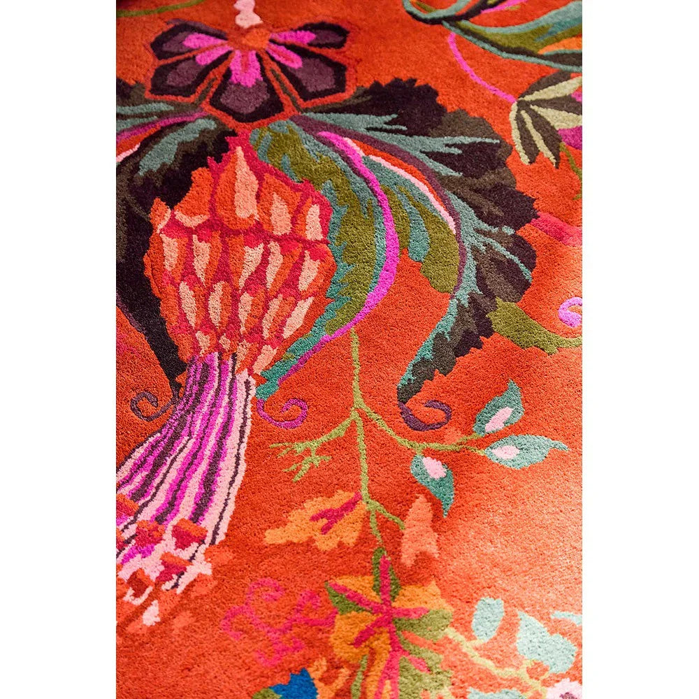 Sophie Robinson x Harlequin Wonderland Floral Rug featuring botanical pattern in amber, lapis blue, pink on orange background, hand-tufted wool