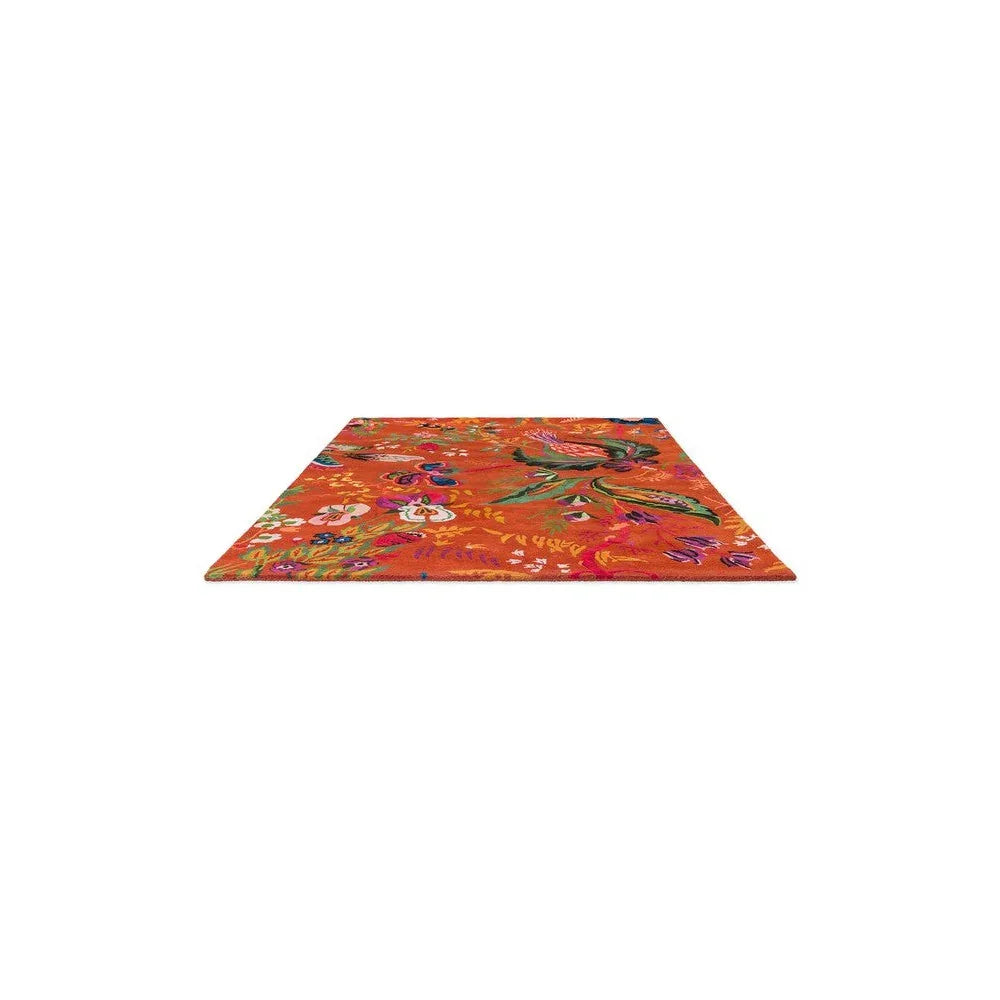 Sophie Robinson x Harlequin Wonderland Floral Rug featuring vibrant floral pattern in amber, pink, purple on orange background, hand-tufted wool