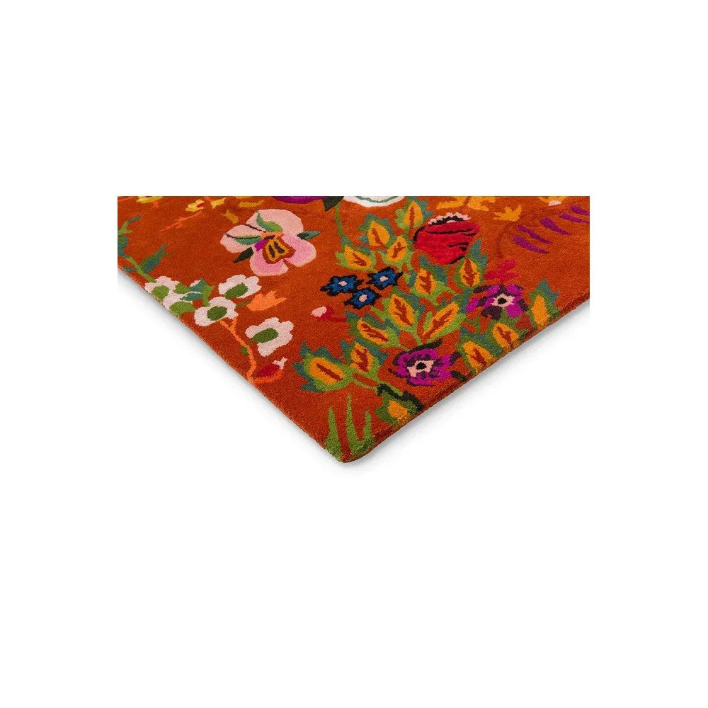 Sophie Robinson x Harlequin Wonderland Floral Amber/Lapis Designer Rug featuring vibrant floral pattern in amber, pink, blue, green on orange background