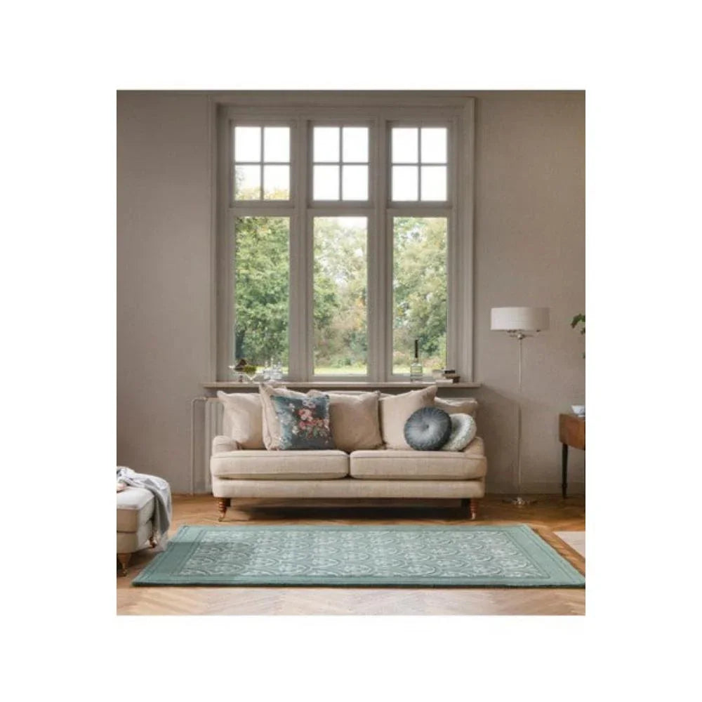 Laura Ashley Catarina Fern Designer Rug featuring botanical pattern in teal, sage and cream on beige background, hand-tufted wool