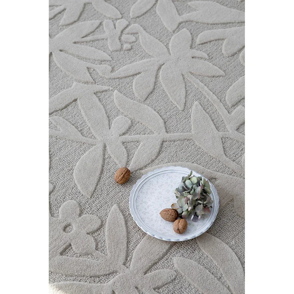 Laura Ashley Cleavers Natural Designer Rug featuring botanical leaf pattern in cream and beige on beige ground, hand-tufted wool