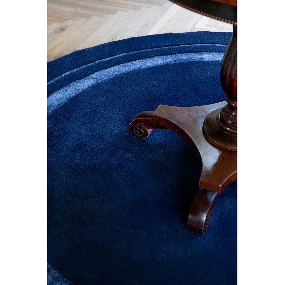 Laura Ashley Redbrook Midnight rug featuring solid circular design in midnight navy and royal blue on natural oak floor