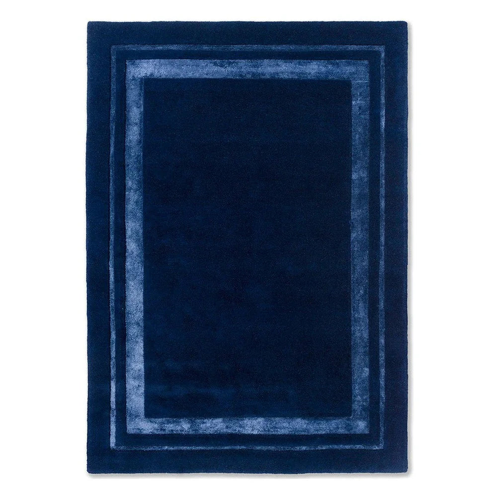 Laura Ashley Redbrook Midnight rug featuring geometric border in navy and light blue on deep navy field, hand-tufted wool