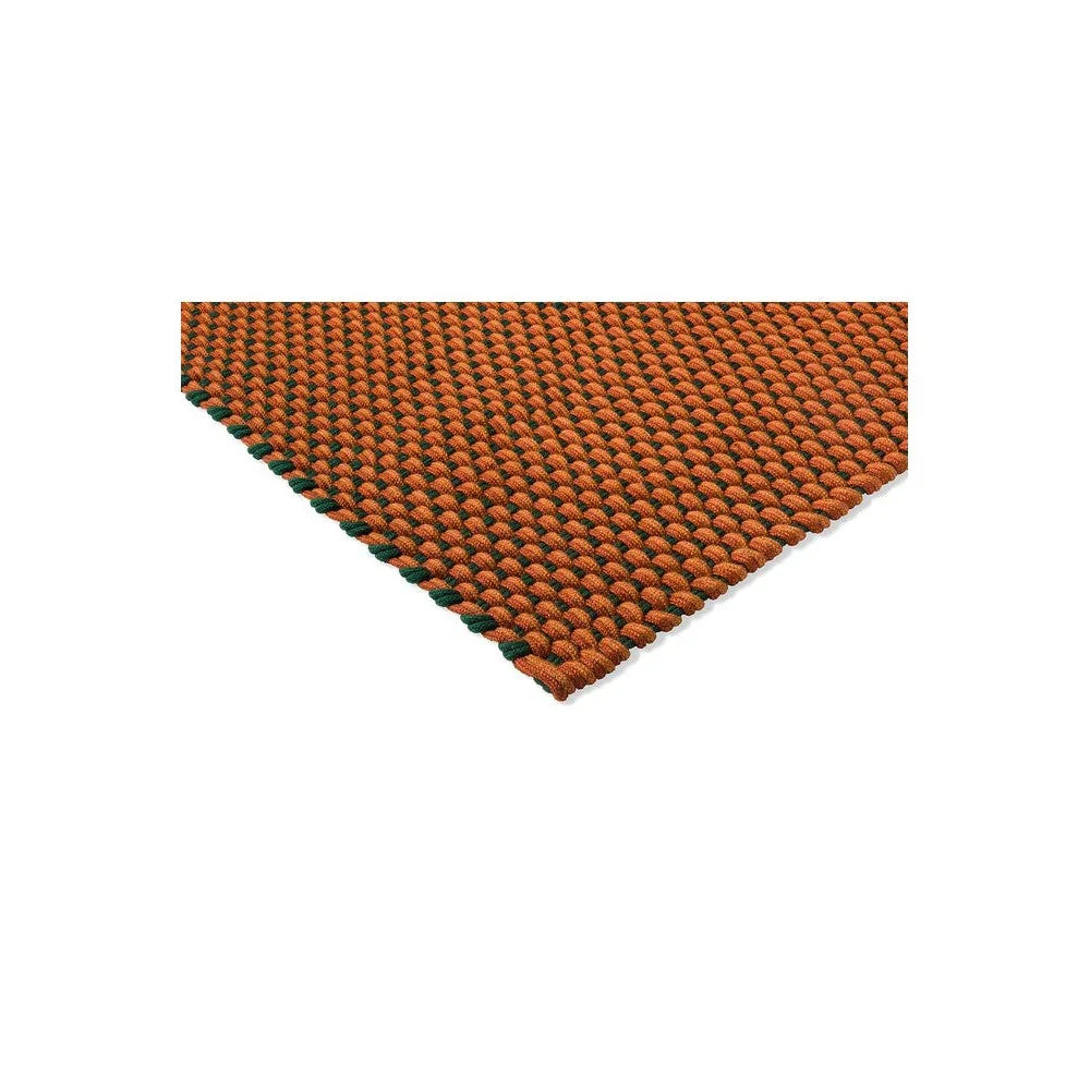 Brink & Campman Lace Tri-colour Terra Outdoor Rug featuring braided loop pattern in orange, terra cotta and dark green on neutral background, hand-woven polypropylene