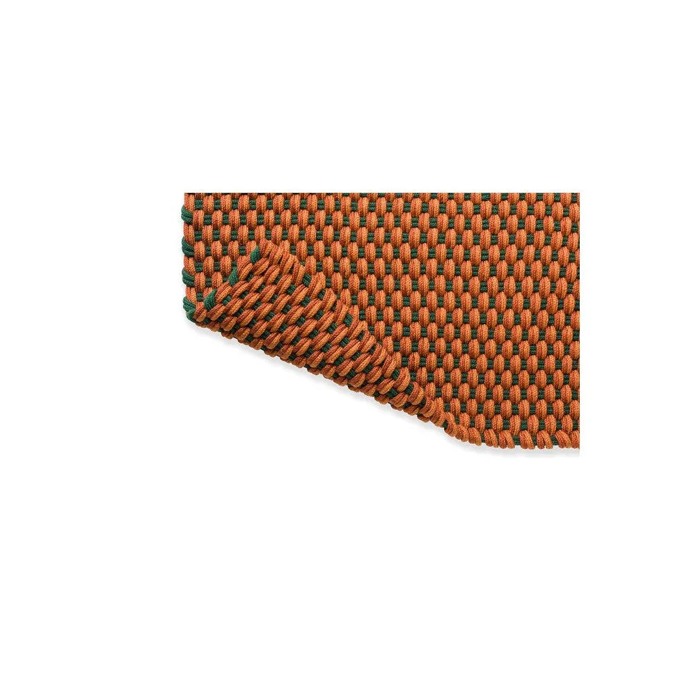 Brink & Campman Lace Tri-colour Terra outdoor rug featuring tight woven pattern in burnt orange, emerald green and tan on a light background, hand-loomed polypropylene