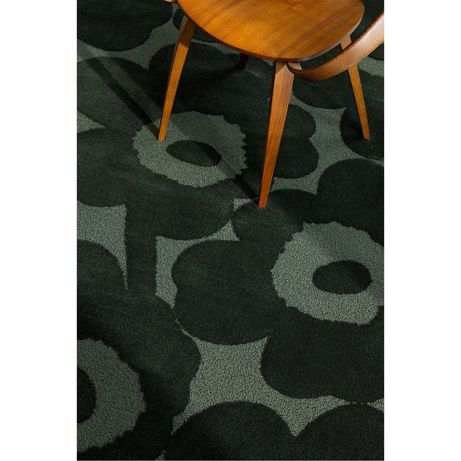 Marimekko Unikko Dark Green Rug featuring bold floral pattern in emerald green, sage green on deep forest background, hand-tufted wool