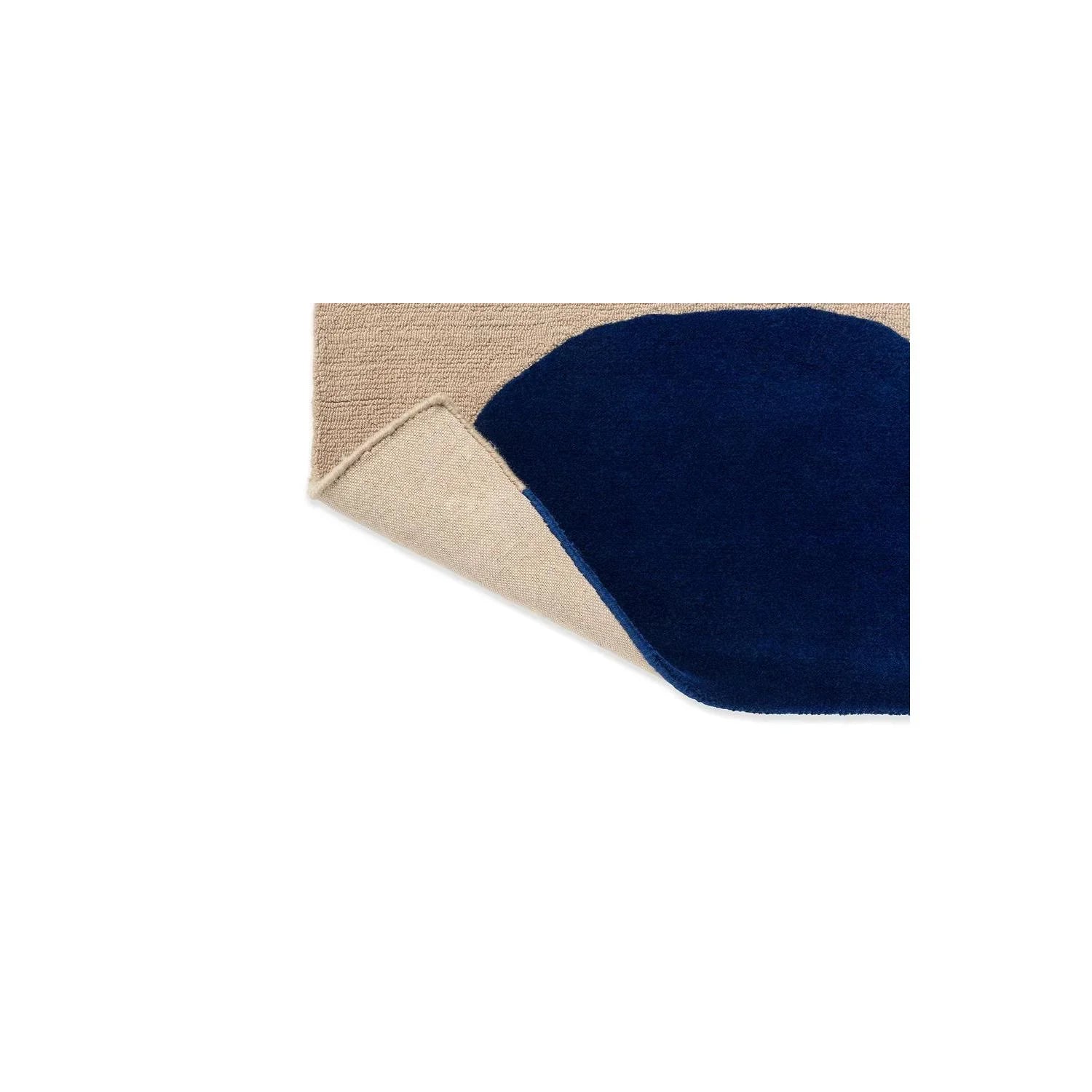 Marimekko Isot Kivet Blue rug featuring navy blue pebble shapes on beige background, hand-tufted wool