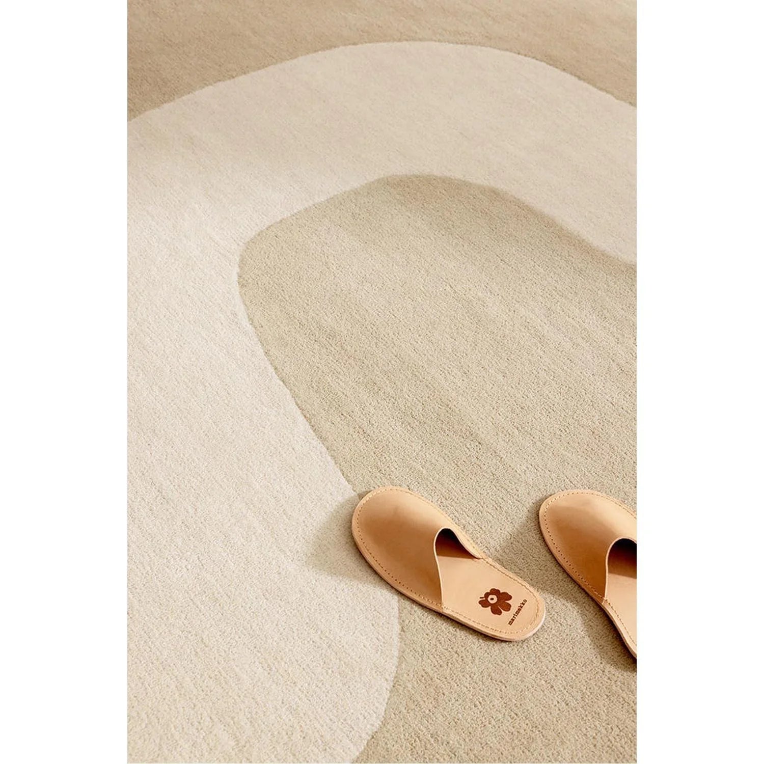 Marimekko Seireeni warm beige rug featuring abstract circular pattern in warm beige, cream on light cream background, hand-tufted wool