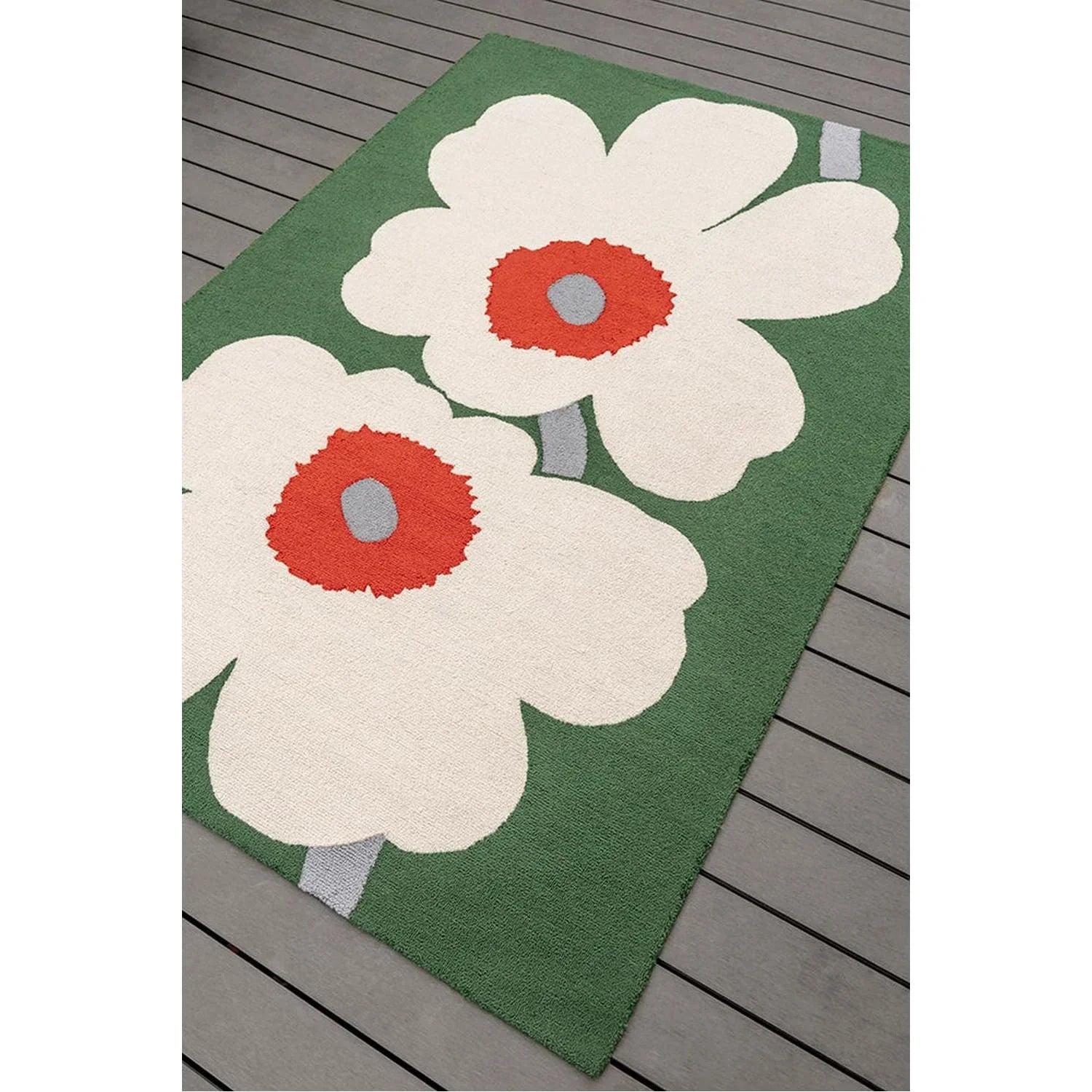 Marimekko Unikko 60th Anniversary Green Rug featuring bold white poppy motif with orange centers on green background, machine-woven wool