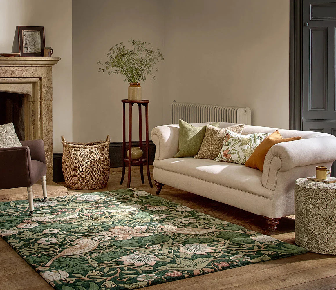 Morris & Co Strawberry Thief Forest Rug featuring botanical floral pattern in forest green, sage, cream and pink on warm beige floor, hand-tufted wool