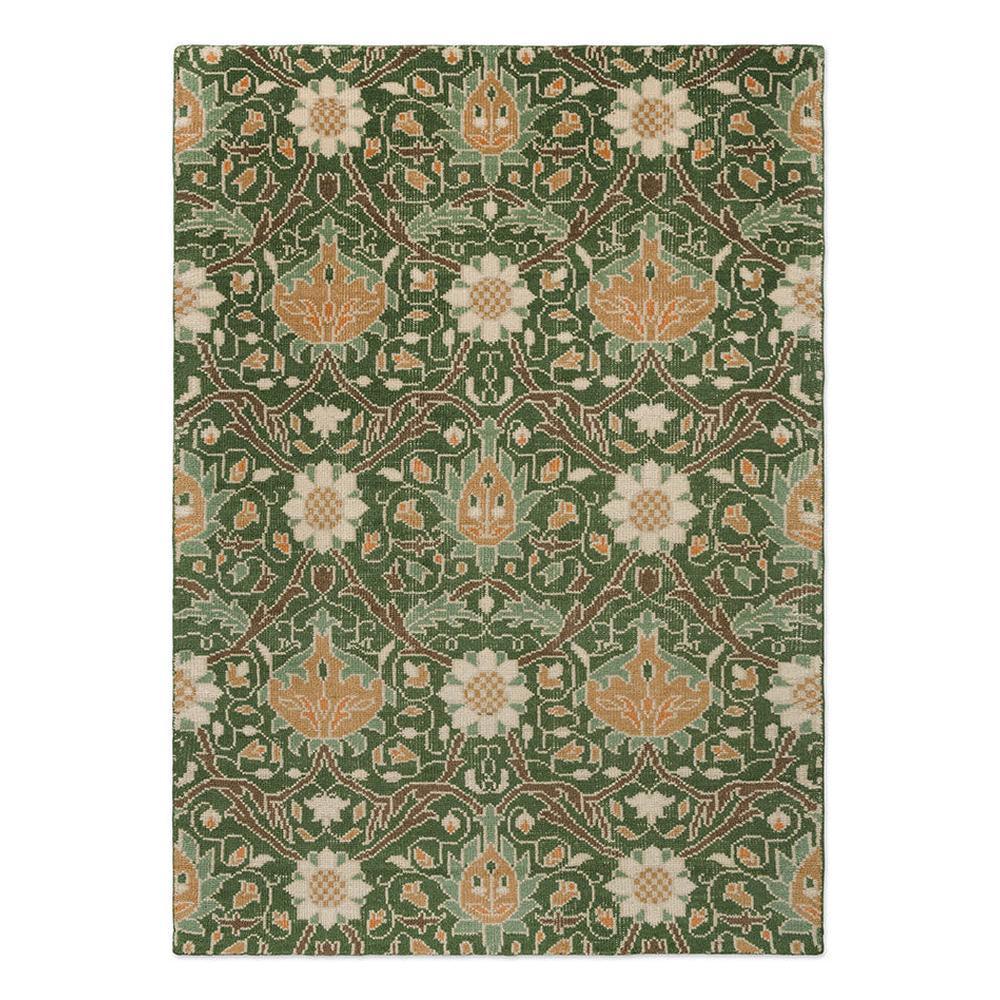 Morris and Co Montreal Forest hand-knotted wool rug featuring John Henry Dearle 1890s Persian-inspired design with oversized trailing flowers in terracotta, golden tan, and cream on deep forest green background
