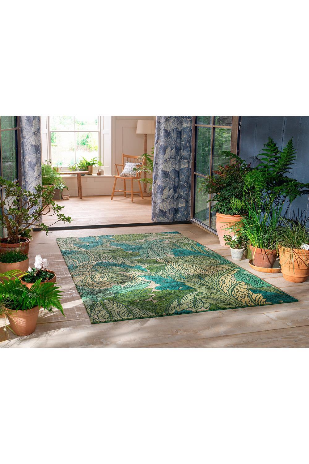 Morris & Co Acanthus Nettle Sky Blue outdoor rug featuring botanical leaves in emerald, teal and cream on light beige, machine-woven polypropylene