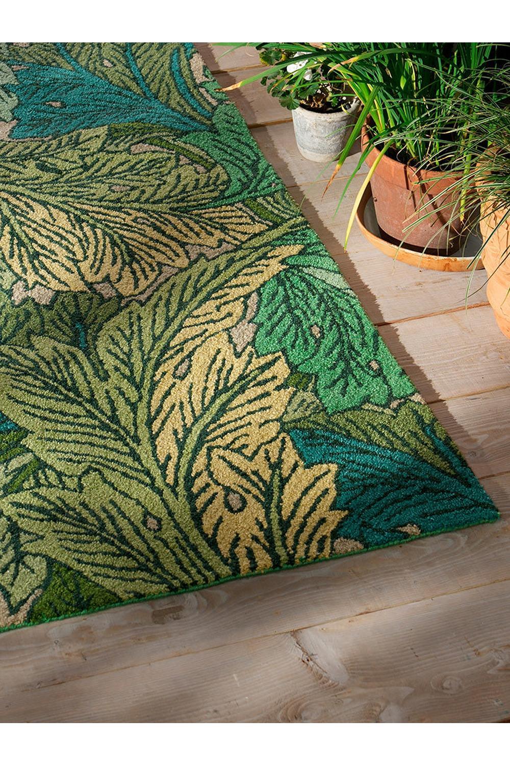 Morris & Co Acanthus Nettle Outdoor Rug featuring botanical leaves in emerald green, teal and beige on sky blue background, power-loomed polypropylene