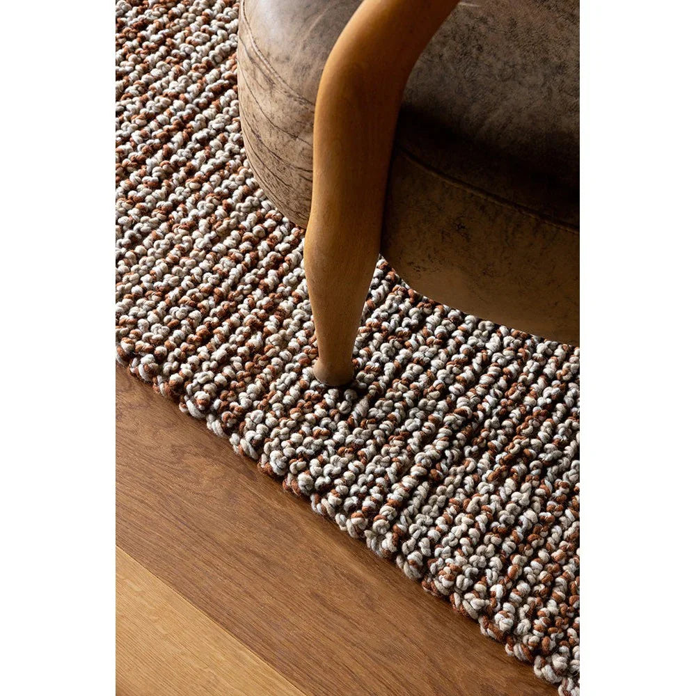Brink & Campman Nest Leather Rug with chunky braided texture in brown, cream, tan, rust on wood floor, hand-tufted wool