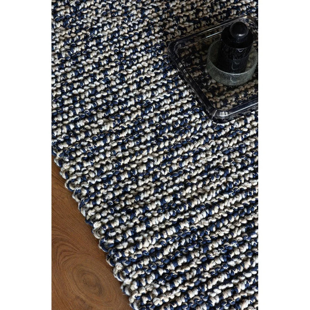 Brink & Campman Nest Ink Rug featuring textured looped pattern in navy, cream and grey on brown wood floor, hand-tufted wool