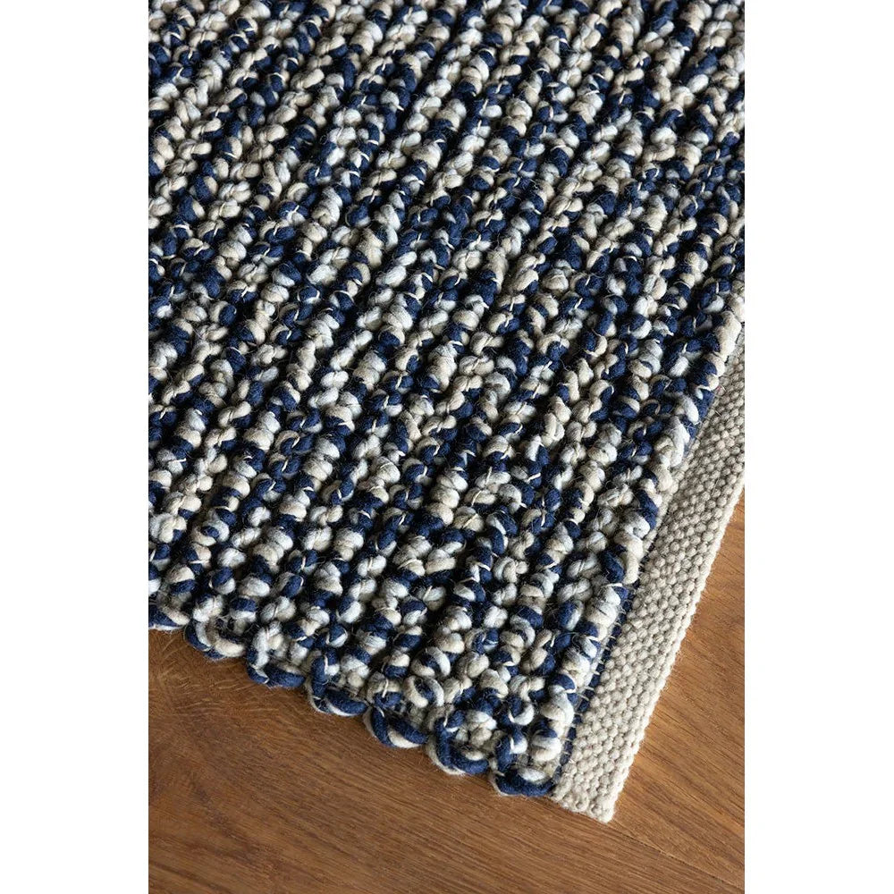 Brink & Campman Nest Ink rug featuring chunky braided pattern in navy, ivory and beige on natural beige background, hand-tufted wool