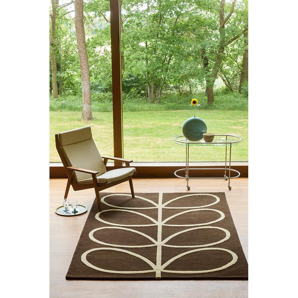 Orla Kiely Giant Linear Stem Walnut rug featuring linear stem pattern in cream/beige on walnut brown background, hand-tufted wool