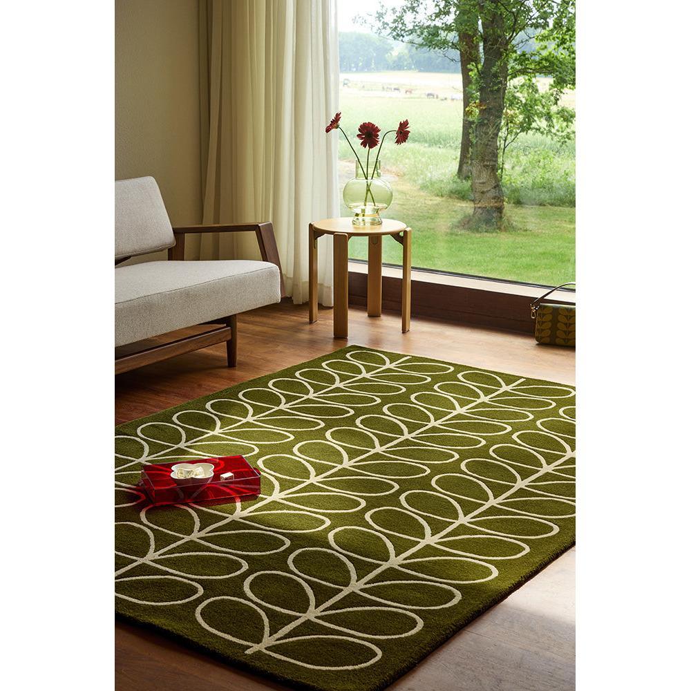 Orla Kiely Linear Stem Olive Designer Rug featuring looping stem pattern in white on olive green background, hand-tufted wool
