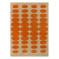 Orla Kiely Optical Oval Orange Sand hand-tufted wool rug featuring hypnotic interlocking oval pattern in rich burnt orange on soft sand beige background
