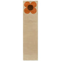 Orla Kiely Flower Placement Pumpkin Ecru runner rug featuring oversized iconic flower bloom in warm pumpkin orange with chocolate brown centre dramatically placed on soft ecru cream background
